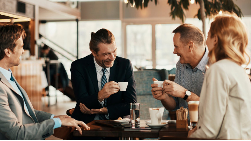 Faculty Social Hour - Four people sitting around a table in a cafe setting